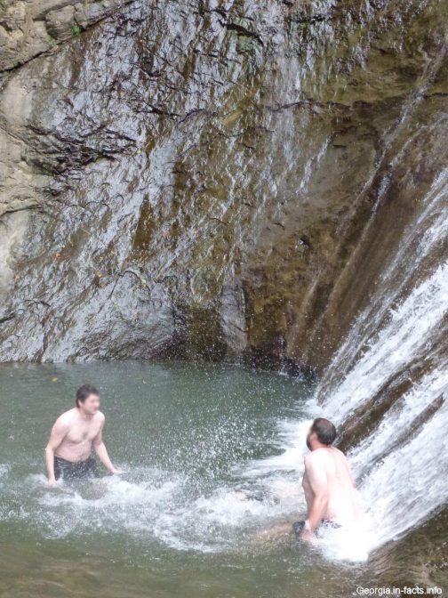 Смелые мужчины, купающиеся в чаше водопада Махунцети
